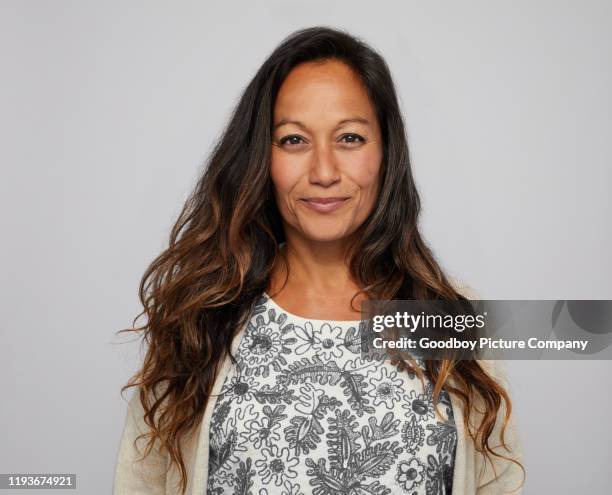 rijpe vrouw lachend vol vertrouwen voor een grijze achtergrond - pacific islanders stockfoto's en -beelden