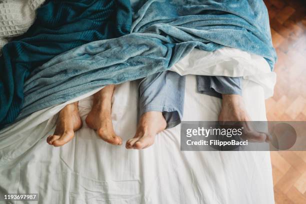 hoge hoek weergave van de voeten liggen in bed - old bed stockfoto's en -beelden