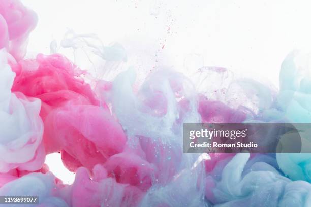 colorful ink swirling in water. - chemistry macro stock-fotos und bilder