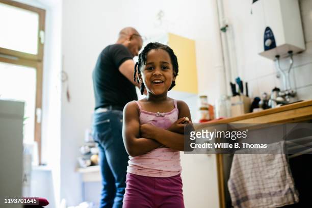 Portrait Of Smiling Young Girl Standing In Kitchen