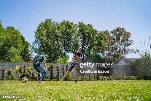 Kids playing football in backyard Kids playing football in backyard