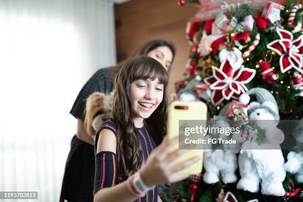 moeder en dochter maken van een videoconferentie in de kersttijd - chat noel stockfoto's en -beelden