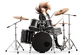 Energetic female drummer throwing her hair and playing drums