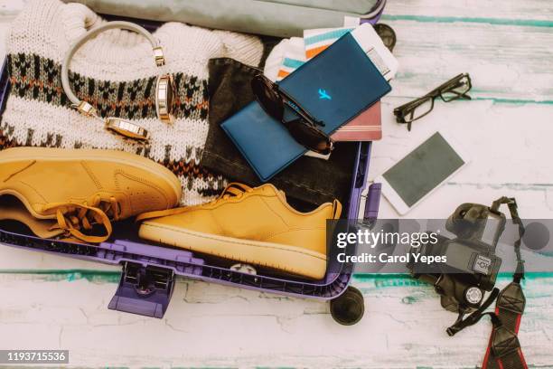 open suitcase with winter travel items. - ski pants stockfoto's en -beelden