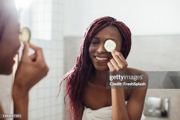 woman using cucumber as eye mask - cucumber eye mask stock pictures, royalty-free photos & images