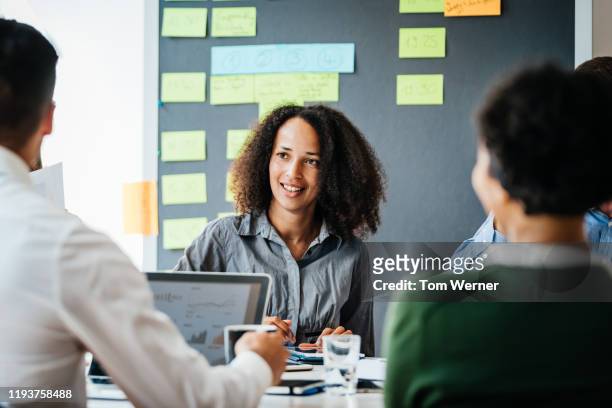 woman sitting down talking to office team - green chalkboard stock pictures, royalty-free photos & images
