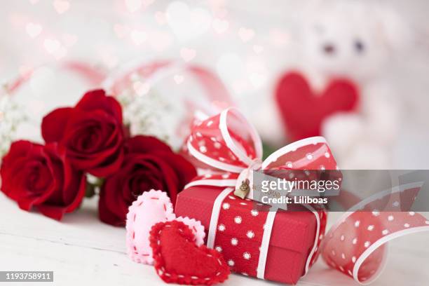 valentinstag geschenk mit roten rosen vor einem weißen hintergrund - heart candy on white stock-fotos und bilder