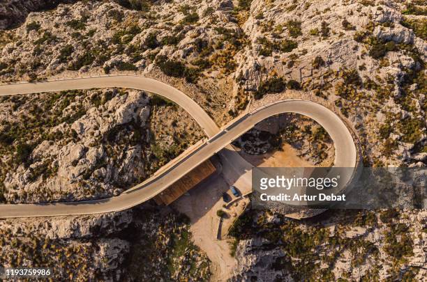 stunning drone view of helicoid curve with eight shape with tunnel in winding road in the mountains of mallorca island. - number 8 stock-fotos und bilder