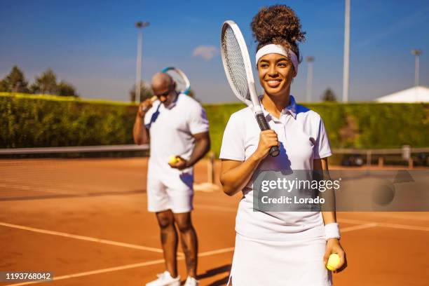 a beautiful black female tennis player on the court - profesional amateur stock pictures, royalty-free photos & images