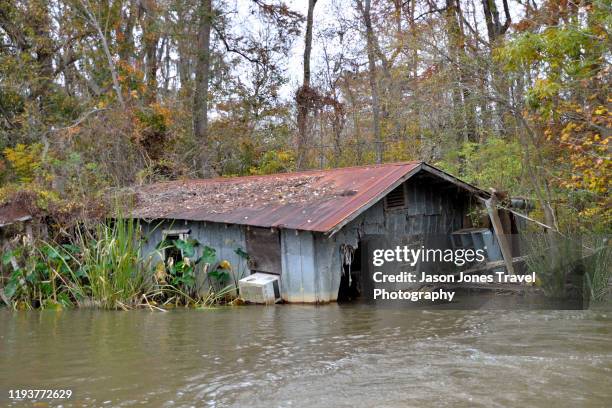 ruined house on the riverbank - sinking stock pictures, royalty-free photos & images