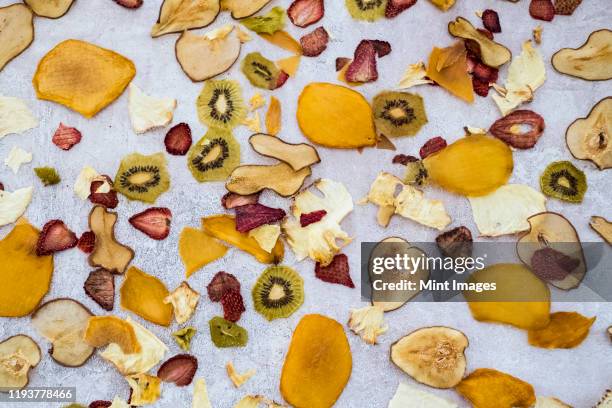 high angle close up slices of dried fruit including mango, apple, kiwi and strawberry. - trockenobst stock-fotos und bilder