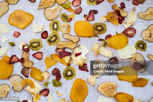 high angle close up slices of dried fruit including mango, apple, kiwi and strawberry. - gedroogd fruit stockfoto's en -beelden