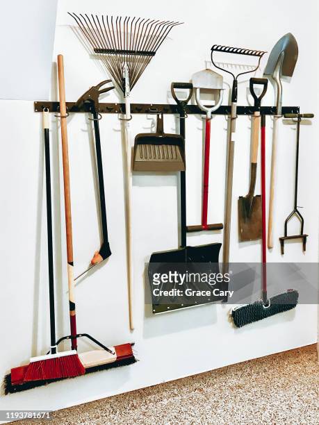 yard tools hang on garage wall - garage tools stock pictures, royalty-free photos & images