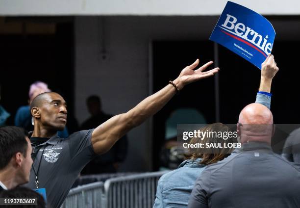 Security guard tries to grab a sign from a protester supporting Democratic presidential hopeful US Senator Bernie Sanders as US President Donald...