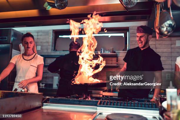 flammende pfanne als teil eines speziellen rezepts in der modernen küche - brand advocacy stock-fotos und bilder
