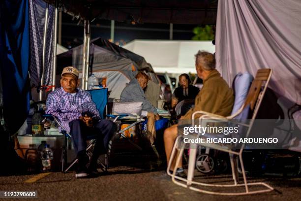 People sleep at a tent city shelter in a baseball stadium parking lot in Yauco, Puerto Rico on January 14 after a powerful earthquake hit the island....