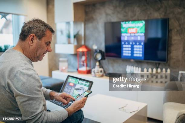 mature man using mobile app for live betting - internet gambling stock pictures, royalty-free photos & images