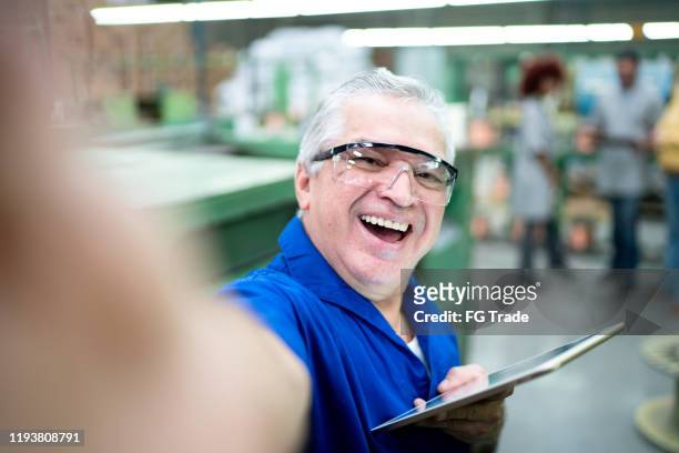 retrato de un ingeniero tomando selfies en una fábrica - safety funny fotografías e imágenes de stock