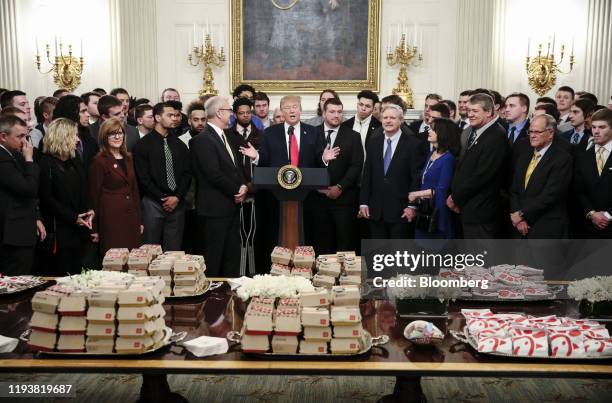 President Donald Trump, center, speaks behind a table of fast food as he welcomes the 2018 Division 1 Football National Champions, the North Dakota...