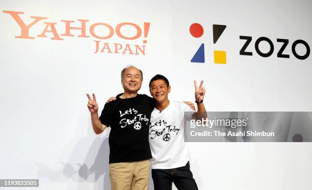 SoftBank Group CEO Masayoshi Son and Zozo founder Yusaku Maezawa pose for photographs during a press conference on September 12, 2019 in Tokyo,...