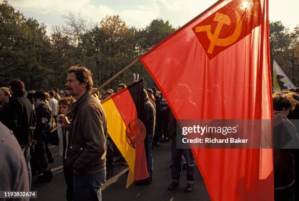 Year after the fall of the Berlin Wall and the end of the Communist Eastern Bloc era, pro-Communist Germans carrying Soviet and DDR flags march in...