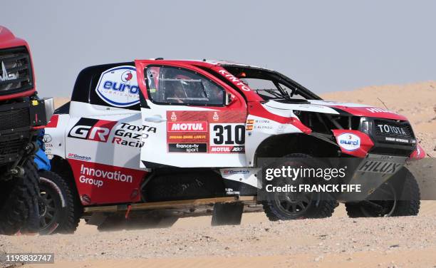 Toyota's Spanish driver Fernando Alonso and and Spanish co-driver Marc Coma drive their car after the neutralisation of the race due to strong winds...