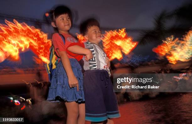 Chinese children smile during a dragon lantern party in Kowloon, on the eve of the handover of sovereignty from Britain to China, on 30th June 1997,...