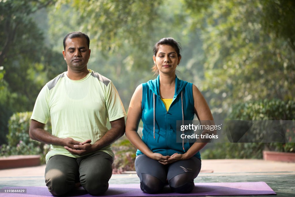 Couple meditating at park