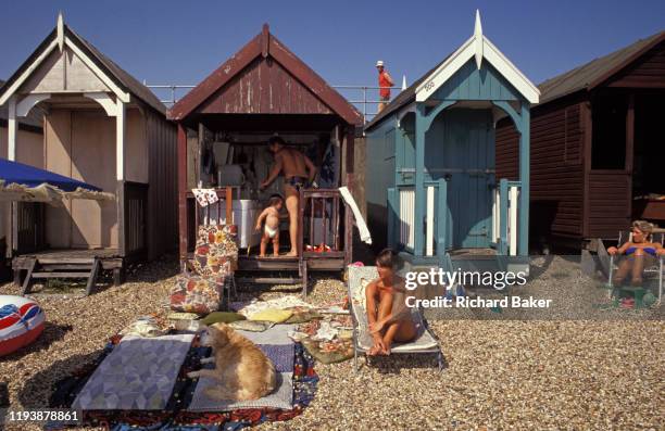 Family enjoy a hot day in their beach hut on the seafront at Southend, on 29th July 2002, in Southend-on-Sea, Essex, England.