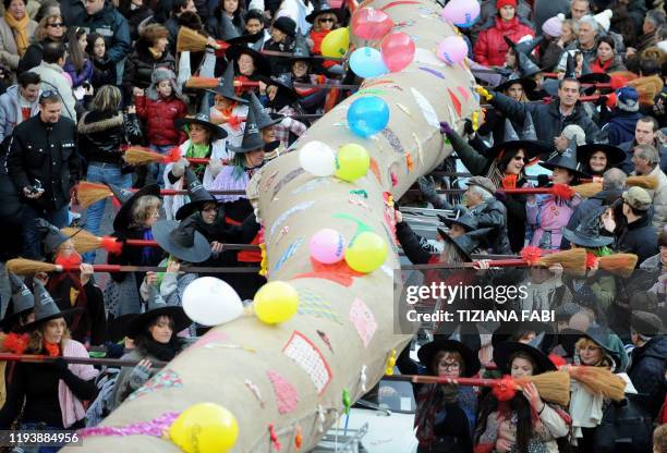 People wearing Befana outfits take part in the annual Befana parade in Viterbo on January 5 on Epiphany Eve. A 52 metres long stocking is carried by...