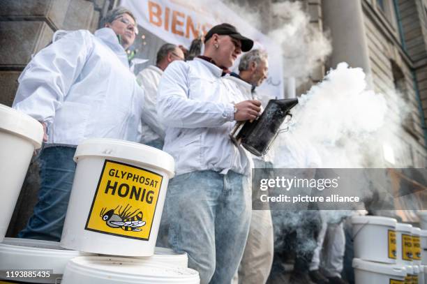 Dpatop - 15 January 2020, Berlin: Beekeepers stand outside the Ministry of Agriculture with four tons of glyphosate-contaminated honey harvest. At...