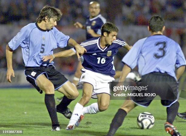 Argentine soccer player Pablo Aimar fights for the ball against Pablo Garcia and Alejandro Lembo of Uruguay, in Montevideo, Uruguay 14 November 2001....