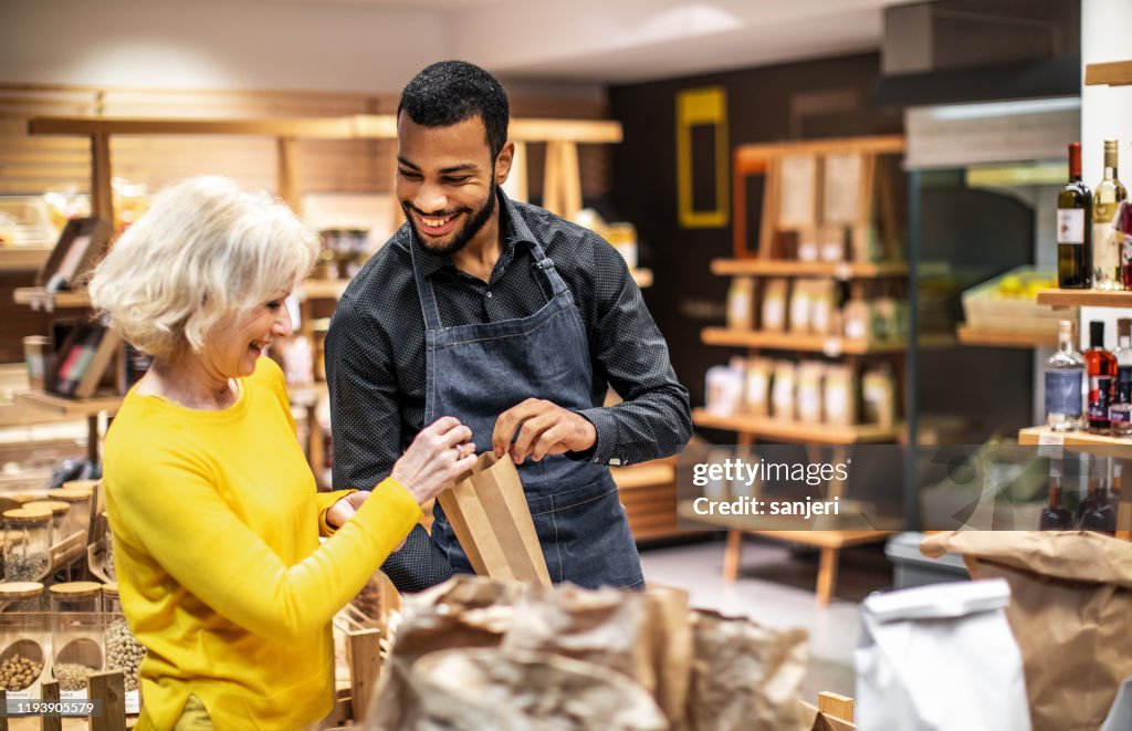 Employee at a bio grocery shop helping a customer