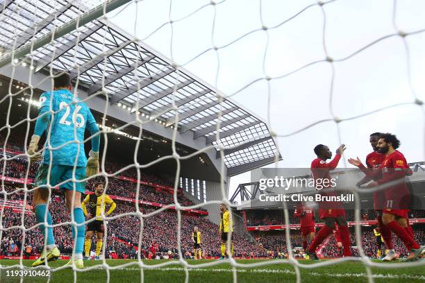 Mohamed Salah of Liverpool celebrates with teammates Sadio Mane and Divock Origi after scoring their team's second goal during the Premier League...