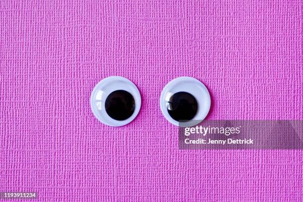 googly eyes on pink - wackelaugen stock-fotos und bilder