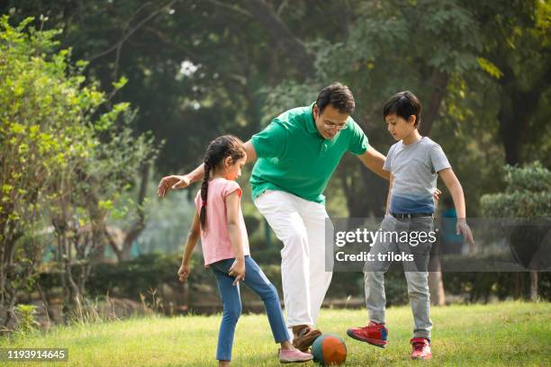 familie spelen met bal in park - sports india stockfoto's en -beelden