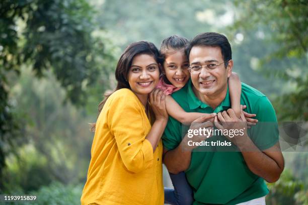 gelukkige familie in park - indian subcontinent ethnicity stockfoto's en -beelden