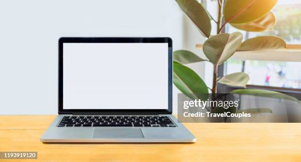 laptop computer blank white screen on table in cafe background. laptop with blank screen on table of coffee shop blur background. - bureau en open space stockfoto's en -beelden