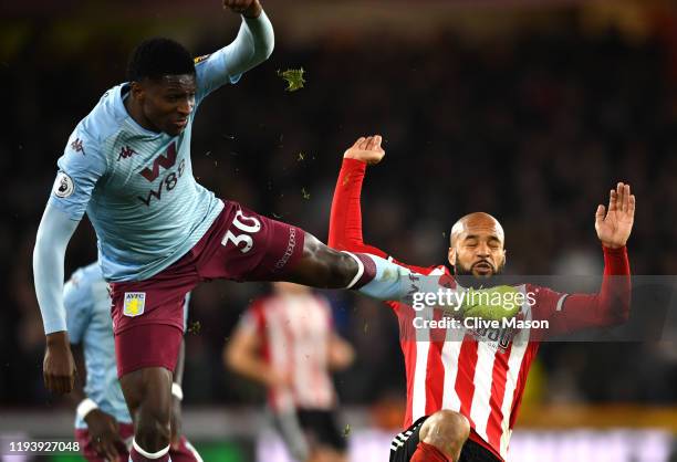 Kortney Hause of Aston Villa tackles David McGoldrick of Sheffield United during the Premier League match between Sheffield United and Aston Villa at...