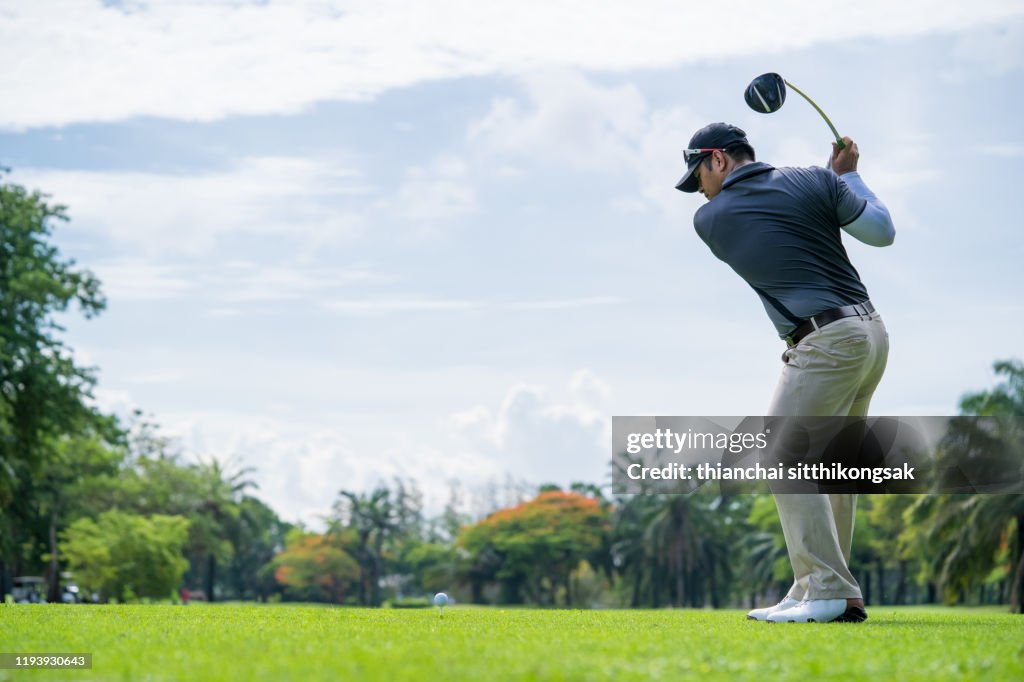 Professional golf player is teeing off on green