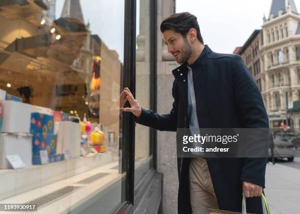 mann auf der straße mit blick auf ein schaufenster - window shopping stock-fotos und bilder