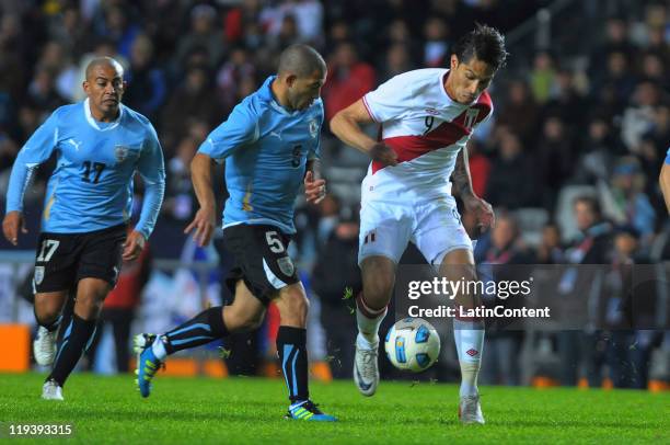 Paolo Guerrero of Peru struggles for the ball with Walter Gargano of Uruguay during a match as part of Finals Quarters of 2011 Copa America at Ciudad...