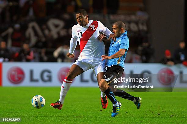 Giancarlo Carmona of Peru struggles for the ball with Walter Gargano of Uruguay during a match as part of Semi Final of 2011 Copa America at Ciudad...