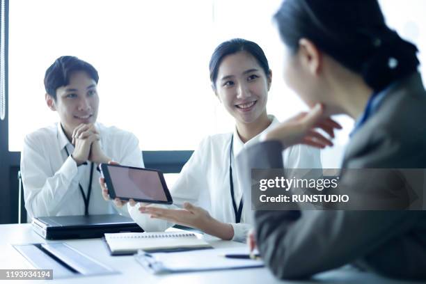 business people reviewing data with digital tablet in meeting - business and japan stock-fotos und bilder