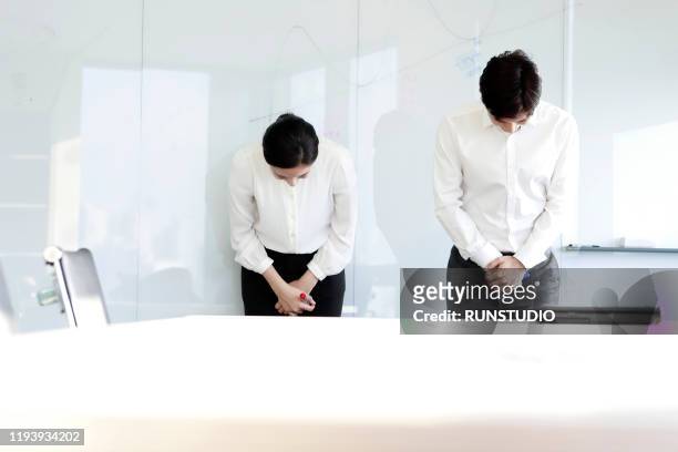 business people taking bow in boardroom - お辞儀 ストックフォトと画像