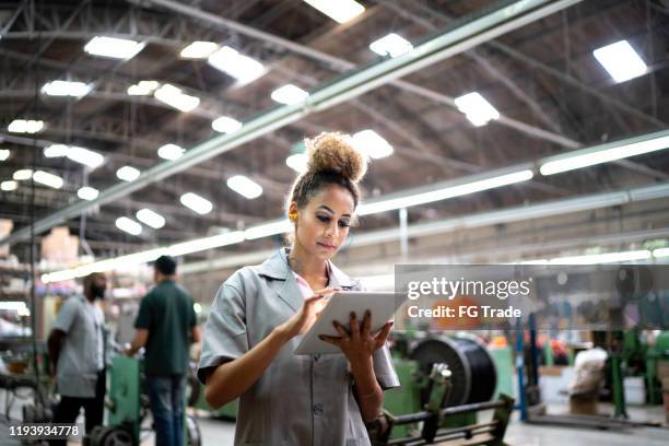 woman using digital tablet in the industry - manufacturing efficiency stock pictures, royalty-free photos & images