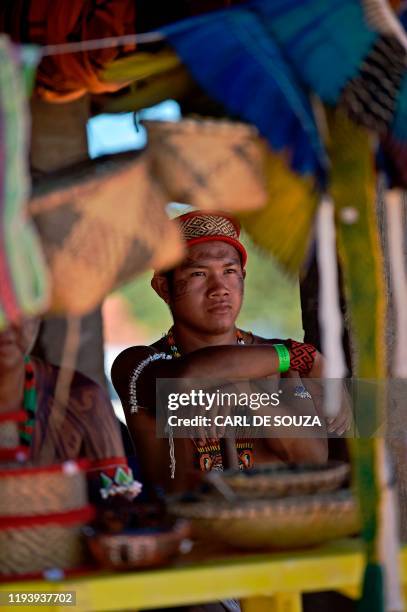 An indigenous tribesman waits to hear a speech by indigenous leader Cacique Raoni of Kayapo tribe looks on, in Piaracu village, near Sao Jose do...