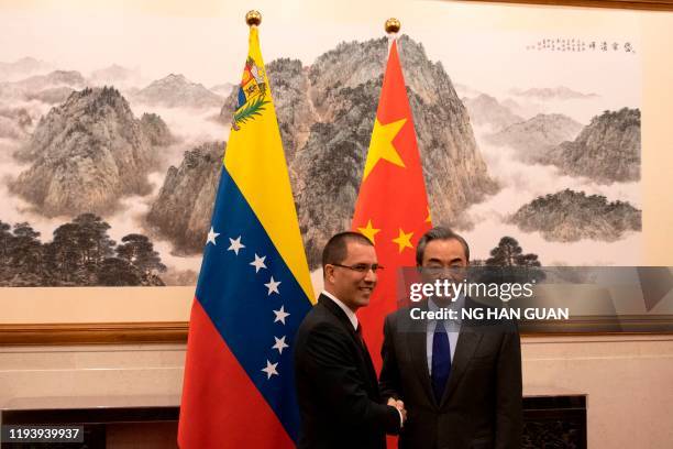 Venezuela's Foreign Minister Jorge Arreaza shakes hands with Chinese Foreign Minister Wang Yi at the Diaoyutai State Guest House in Beijing on...