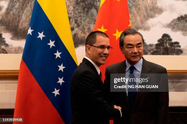 Venezuela's Foreign Minister Jorge Arreaza shakes hands with Chinese Foreign Minister Wang Yi at the Diaoyutai State Guest House in Beijing on...