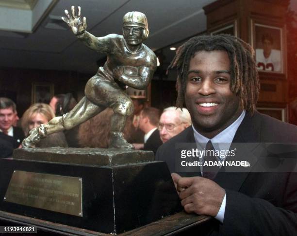 Texas tailback Ricky Williams, winner of the 1998 Heisman trophy, poses with US college football's highest honor 12 December at the Downtown Athletic...